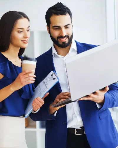 Two colleagues reviewing candidate profiles on a laptop